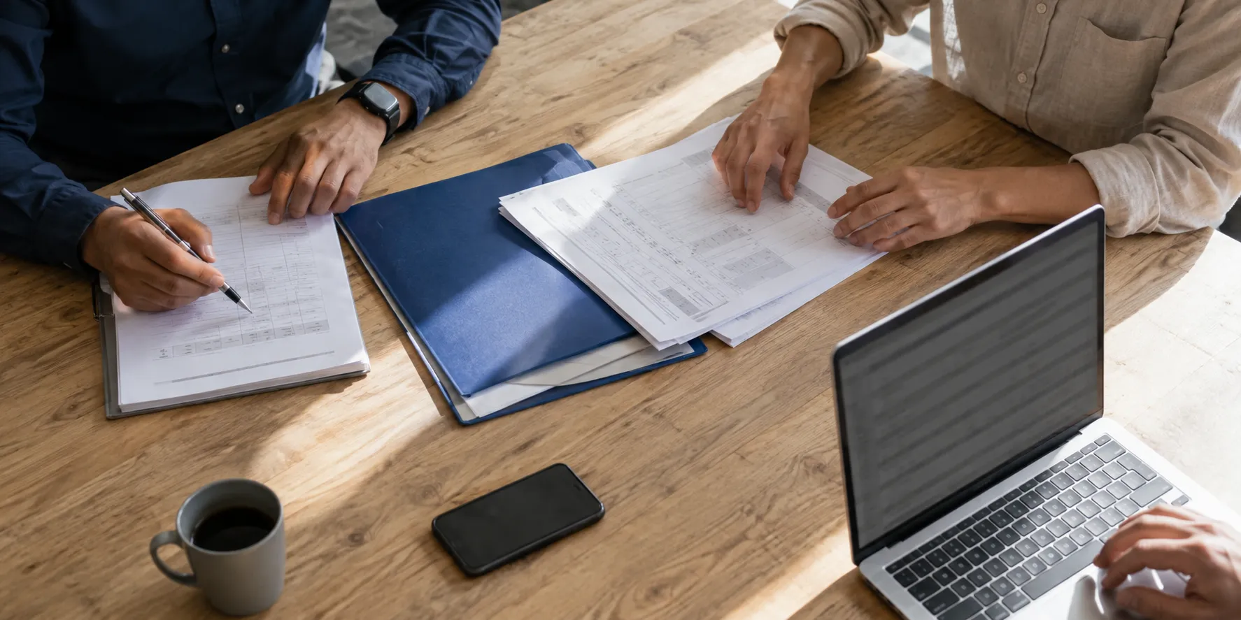 Service records being reviewed together beside a laptop