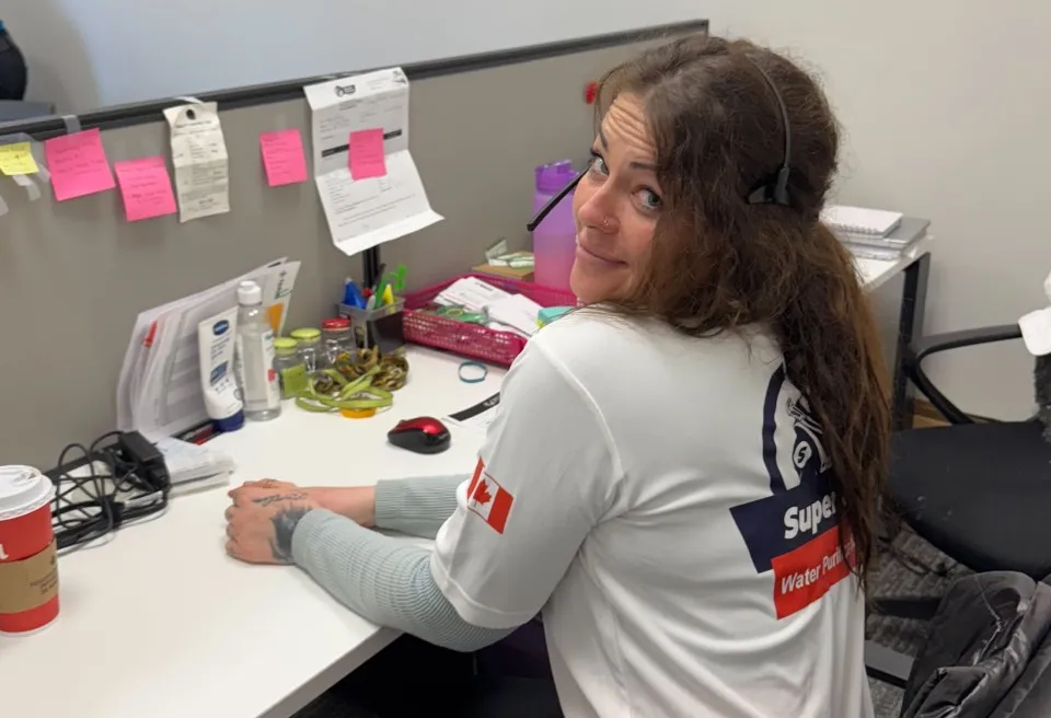 A Superior Plumbing & Heating team member in a headset at the office desk